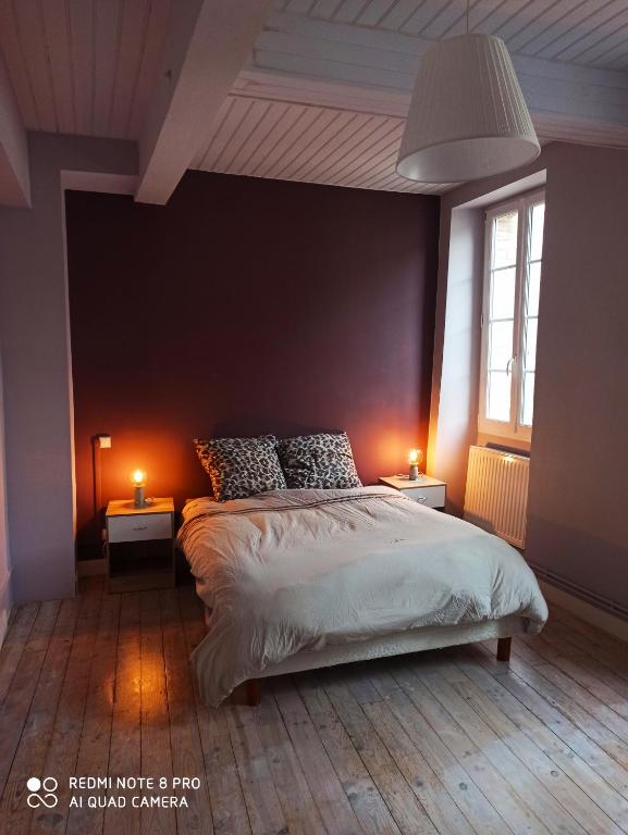 una camera con un grande letto con due lampade sui tavoli di Maison entière au Centre de Villeneuve d'Olmes a Villeneuve dʼOlmes