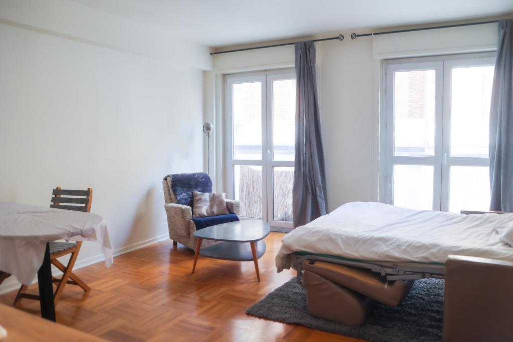 1 dormitorio con 1 cama, 1 silla y 1 ventana en Studio Montmartre, en París