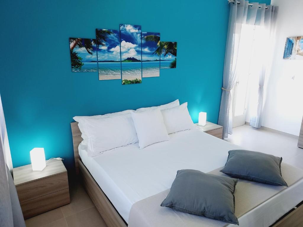 a bedroom with a white bed with a blue wall at Villa Capitani in Torre Canne