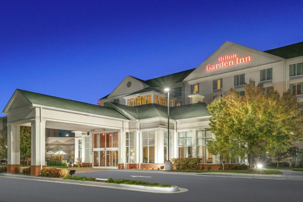 a hotel building with a sign that reads student capital inn at Hilton Garden Inn Richmond Airport in Sandston