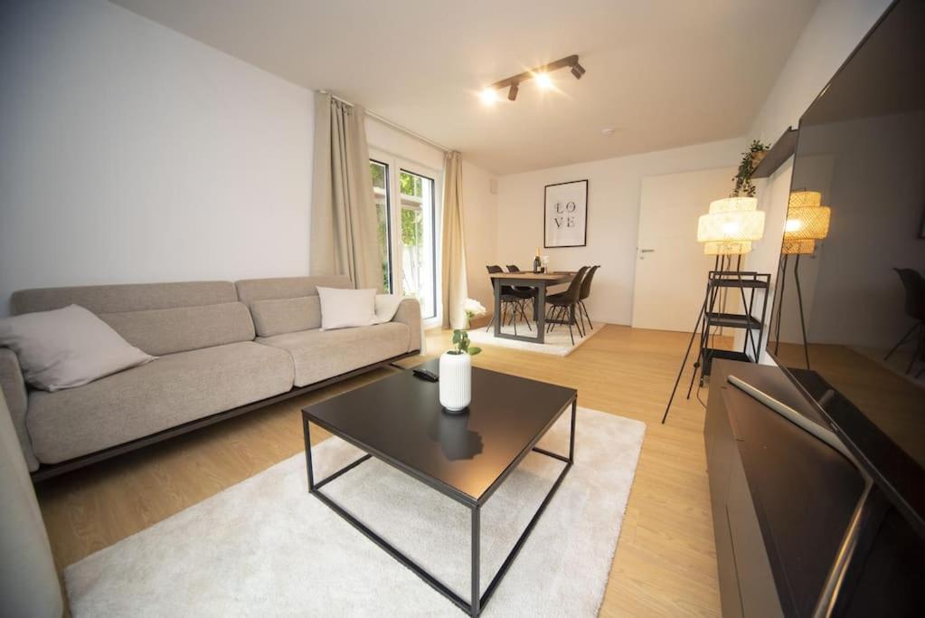 uma sala de estar com um sofá e uma mesa em Central Apartment / BBQ Terrace / Big NetflixTV em Bayreuth