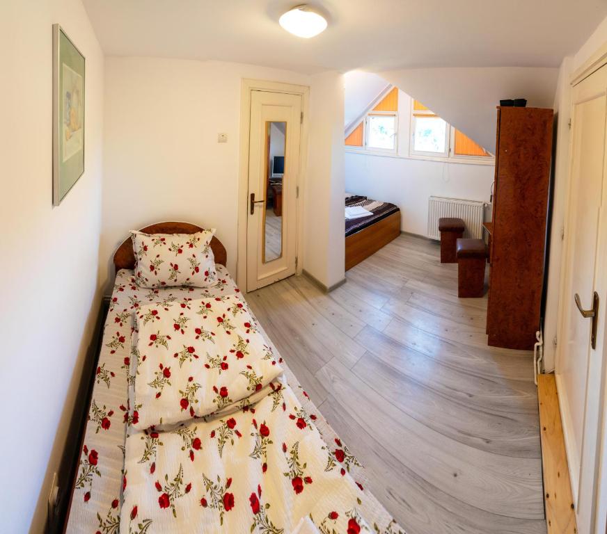 een slaapkamer met een bed met een bloemenbed erop bij Camera 5 - Pensiunea Panorama in Sovata