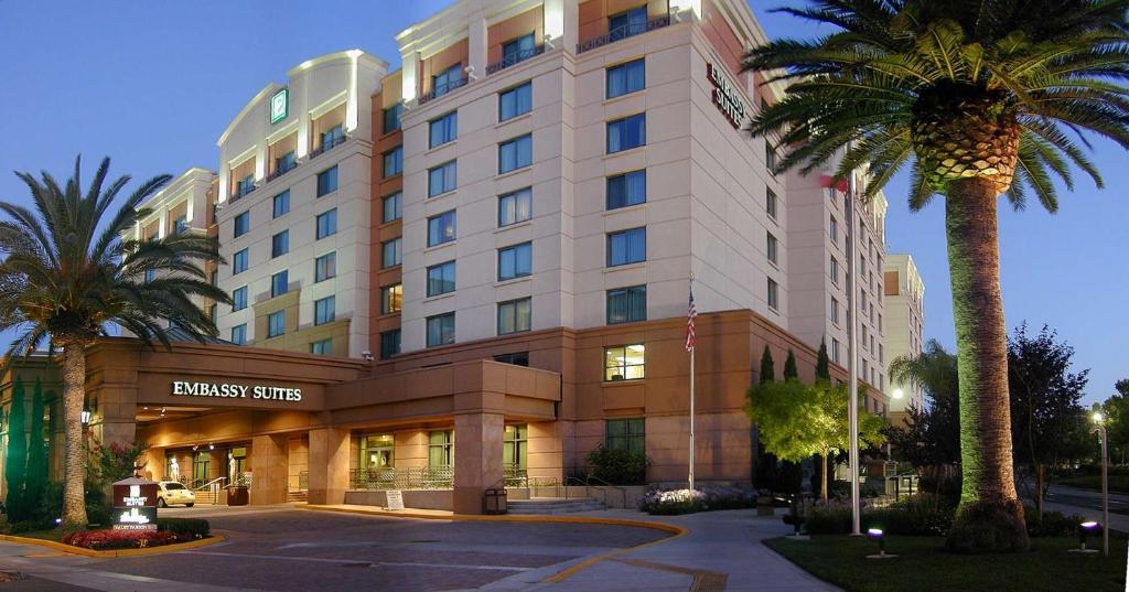 a hotel building with a palm tree in front of it at Embassy Suites by Hilton Sacramento Riverfront Promenade in Sacramento