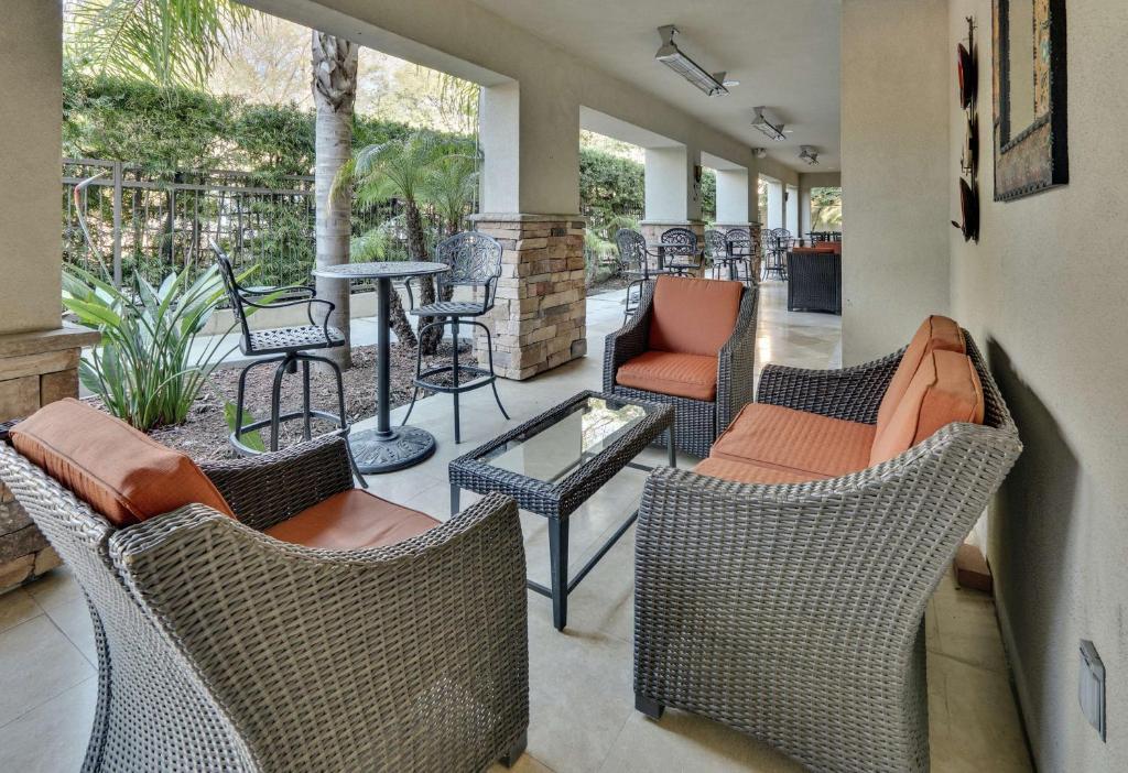 a patio with wicker chairs and a table and chairs at Hilton Garden Inn San Diego Del Mar in San Diego