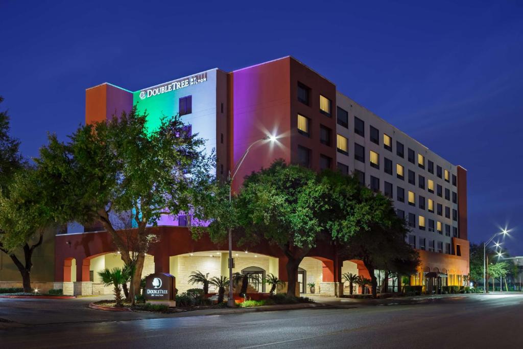 a hotel building with a green sign on it at DoubleTree by Hilton San Antonio Downtown in San Antonio