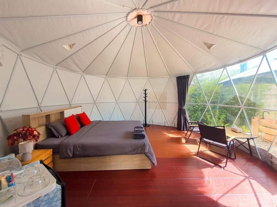 een slaapkamer met een bed in een tent bij ไวน์แคมป์ WineCamp โดมติดลำธาร in Ban Cha-om