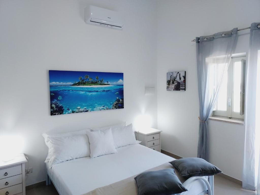 a bedroom with a white bed and a window at Villa Capitani in Torre Canne