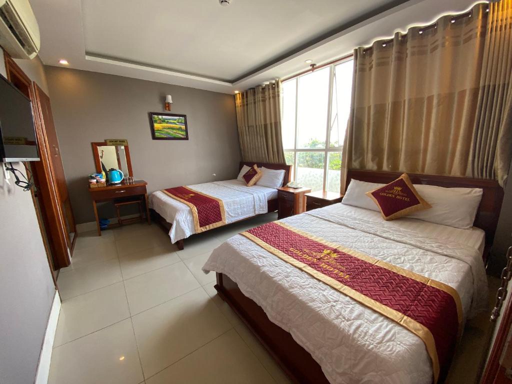 una camera d'albergo con due letti e una finestra di Golden Hotel a Vung Tau