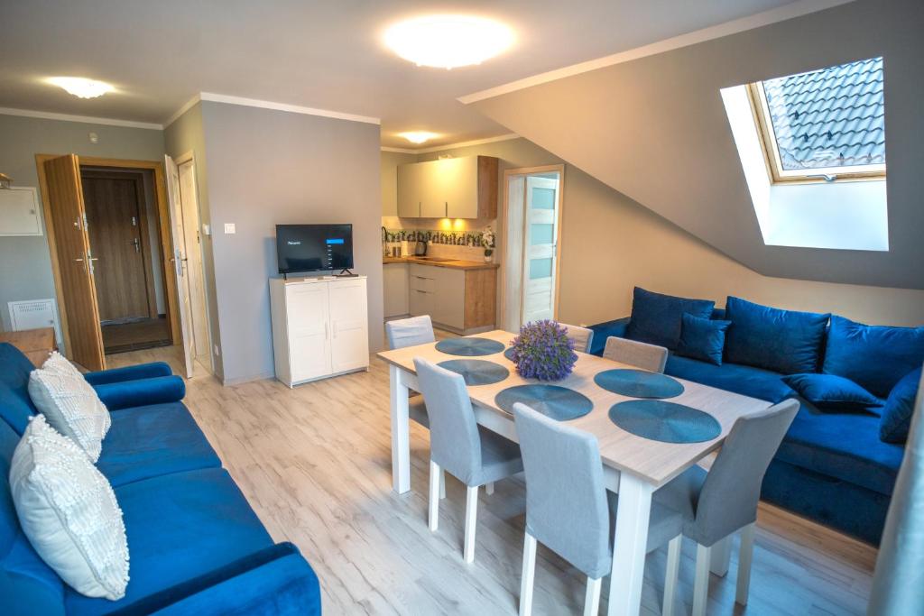 a living room with a table and a blue couch at Szafirowe Oczko in Karpacz
