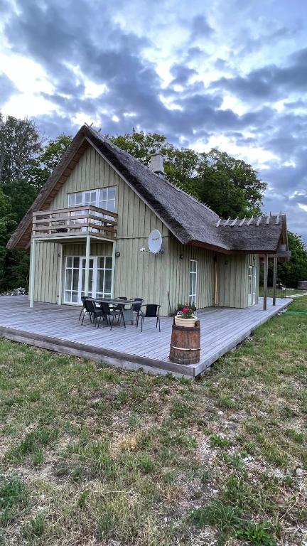 - un bâtiment avec une terrasse dotée d'une table et de chaises dans l'établissement Padaste Rehemae Puhkemaja, à Pädaste