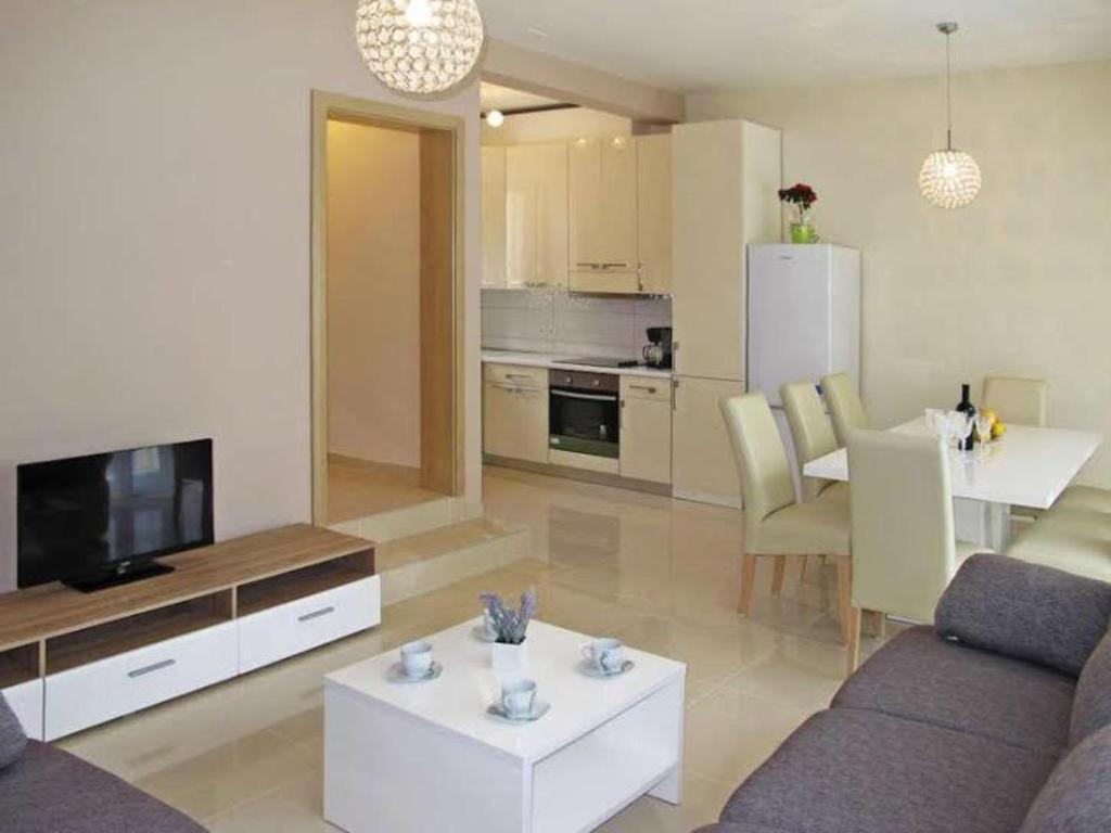 salon z kanapą, telewizorem i stołem w obiekcie 4 bedroom apartment with 3 bathrooms and private parking - Apartments Orange w mieście Zadar