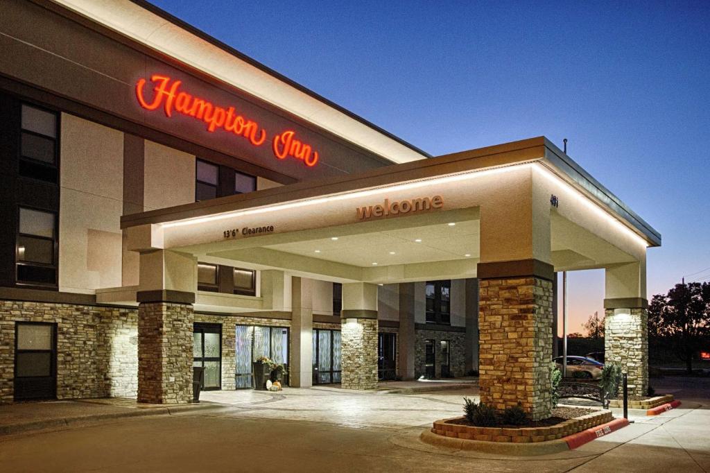 a shopping center with a sign on the front of it at Hampton Inn Salina in Salina