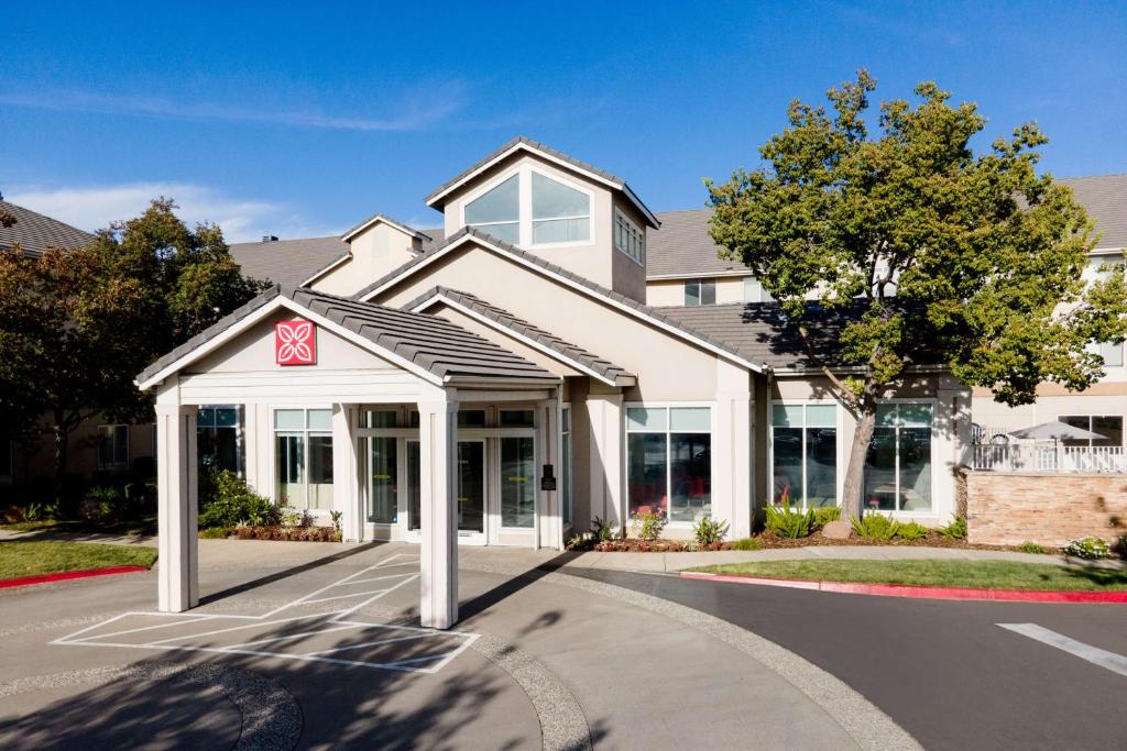 a white building with a sign in front of it at Hilton Garden Inn Roseville in Roseville