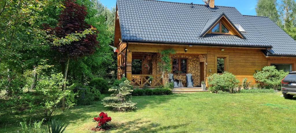 Casa de madera con porche y patio en Dom na mazurach, en Jerutki