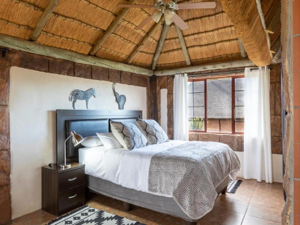 a bedroom with a bed and a ceiling fan at Linglela Lodge in Estcourt