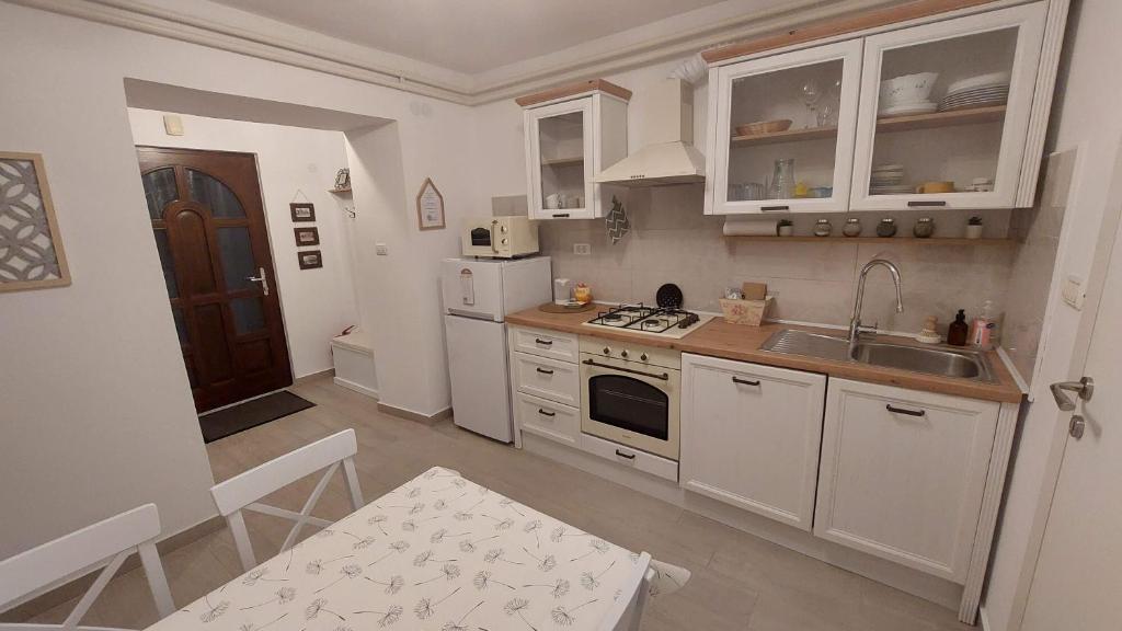a kitchen with white cabinets and a sink at Apartma Rižana in Dekani