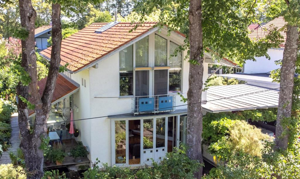 a house with glass doors and trees at 25 Min to the Center - 220 m2 Artist's House South of Munich - for Vacation or Great Workshops in Oberhaching