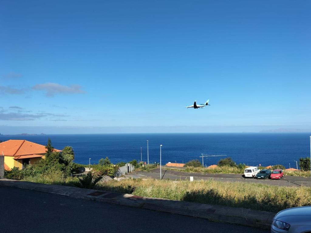 an airplane is flying over a road with the ocean at Sun Hill Apartment in Santa Cruz