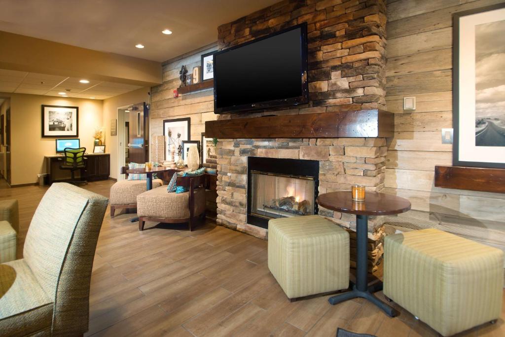 a living room with a fireplace and a flat screen tv at Hampton Inn Tiffin in Tiffin