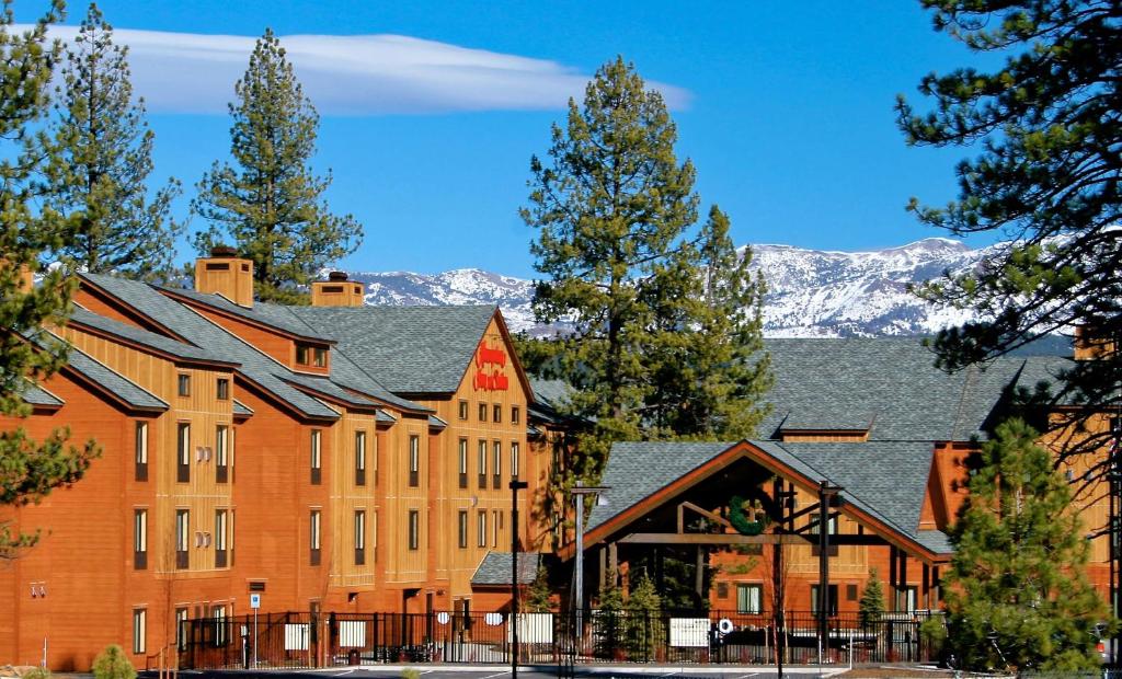 a large brick building with mountains in the background at Hampton Inn & Suites Tahoe-Truckee in Truckee