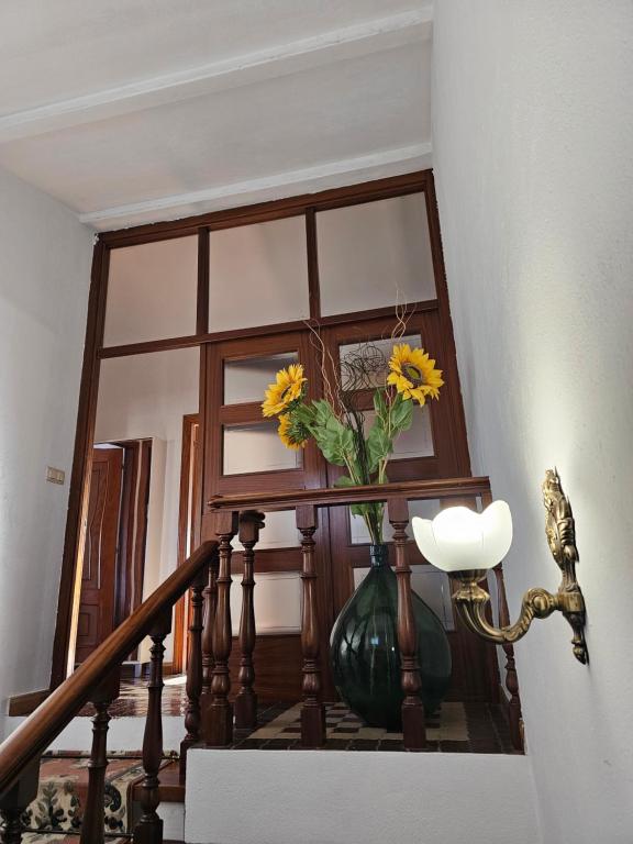 un jarrón con flores amarillas sentado en una escalera en As Rosas apartamentos, en Cambados