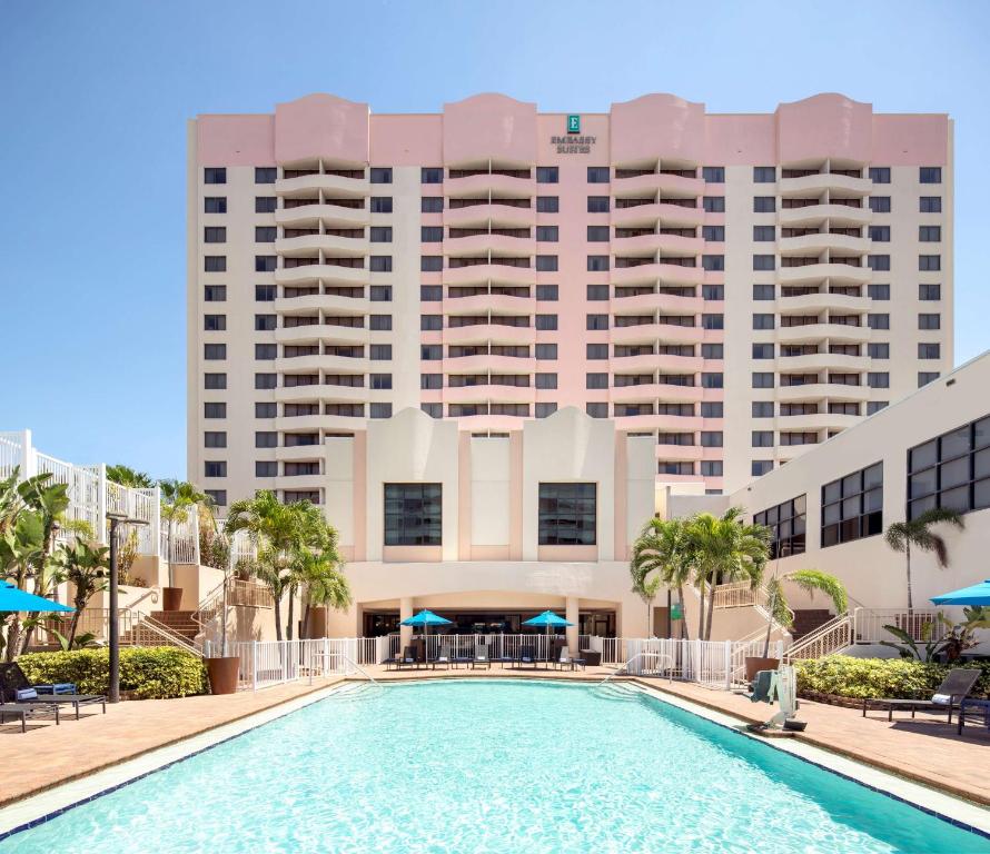 タンパにあるEmbassy Suites by Hilton Tampa Airport Westshoreの建物の前にスイミングプールがあるホテル