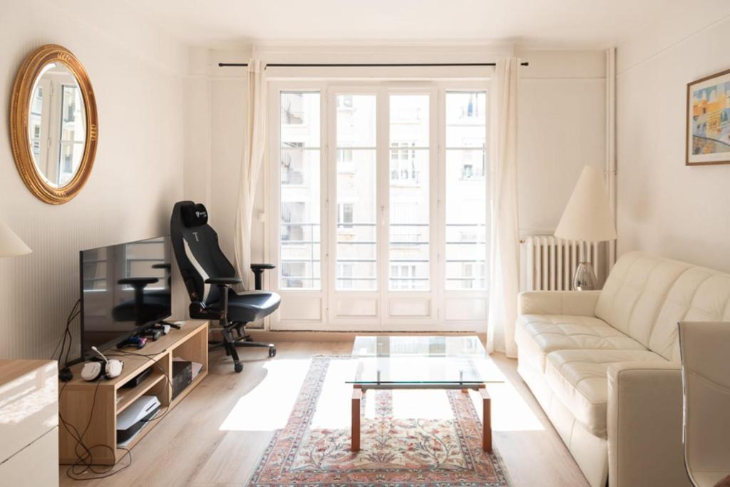 a living room with a couch and a table at Calm and bright cocoon in Paris