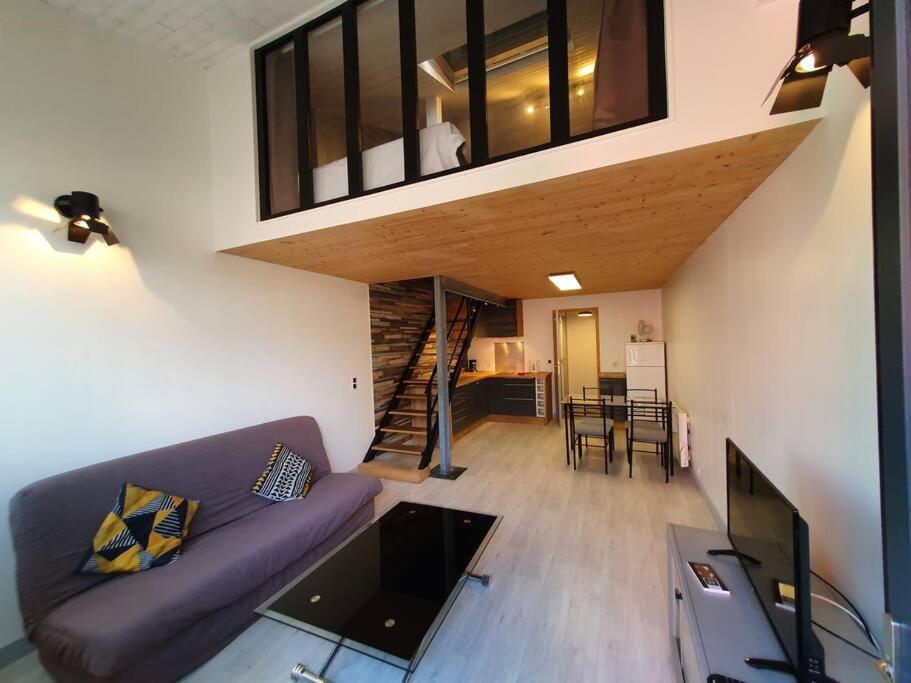 sala de estar con sofá púrpura y escalera en APPARTEMENT CENTRE VILLE AU CALME JARDIN et PARKING PUBLIC, en La Rochelle
