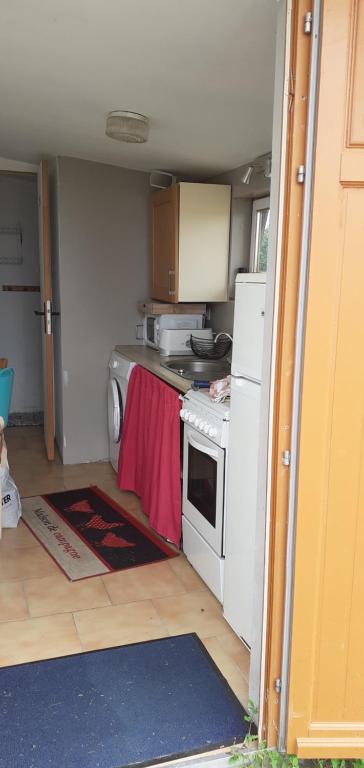 a small kitchen with a stove and a refrigerator at La tente saharienne du Perche .Chevaux. 