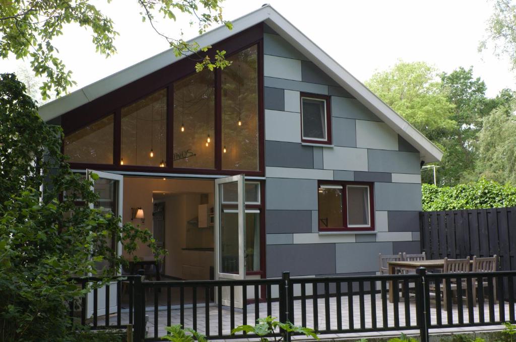 a house with a black fence in front of it at DINOS Bed&Breakfast - Private Guesthouse in Eelderwolde