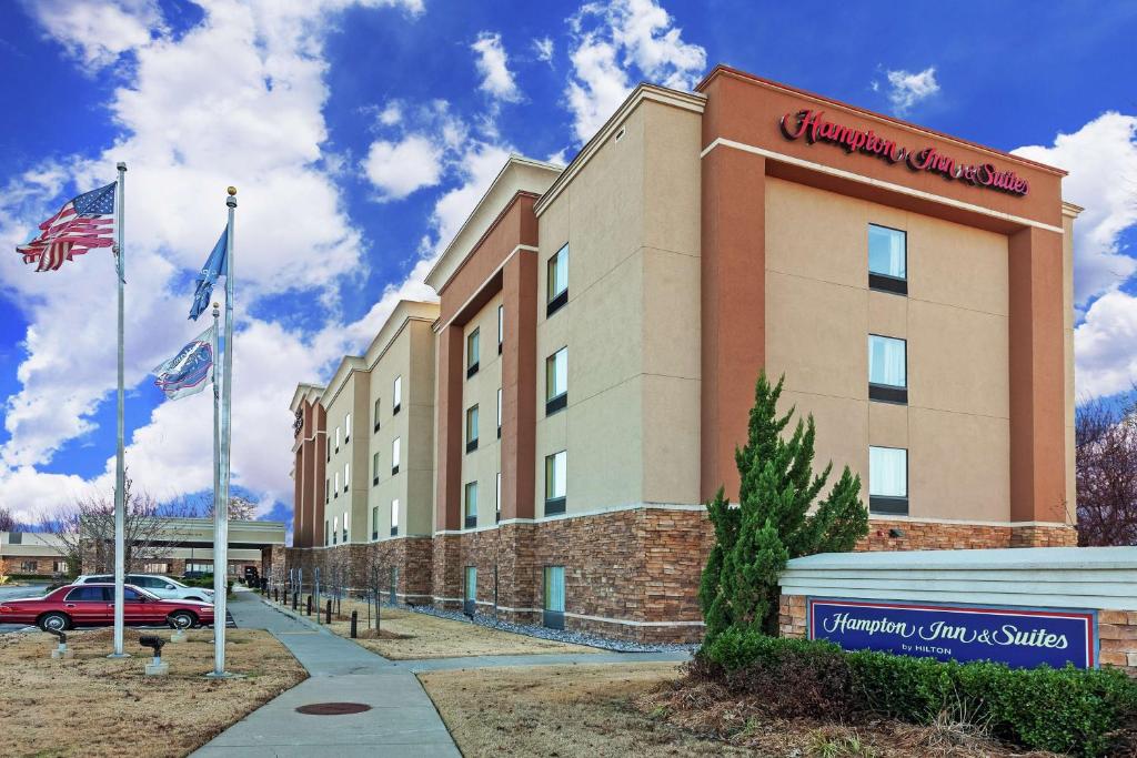 a hotel with two american flags in front of it at Hampton Inn & Suites Owasso in Owasso