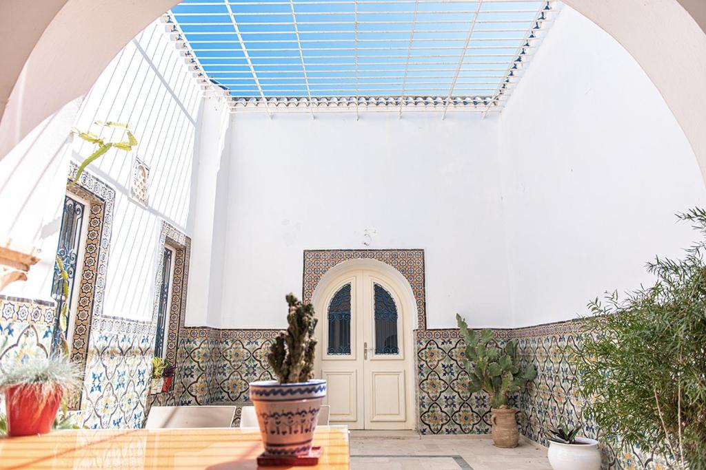 una stanza con una porta e un tavolo con piante di Dar Mayya a La Marsa