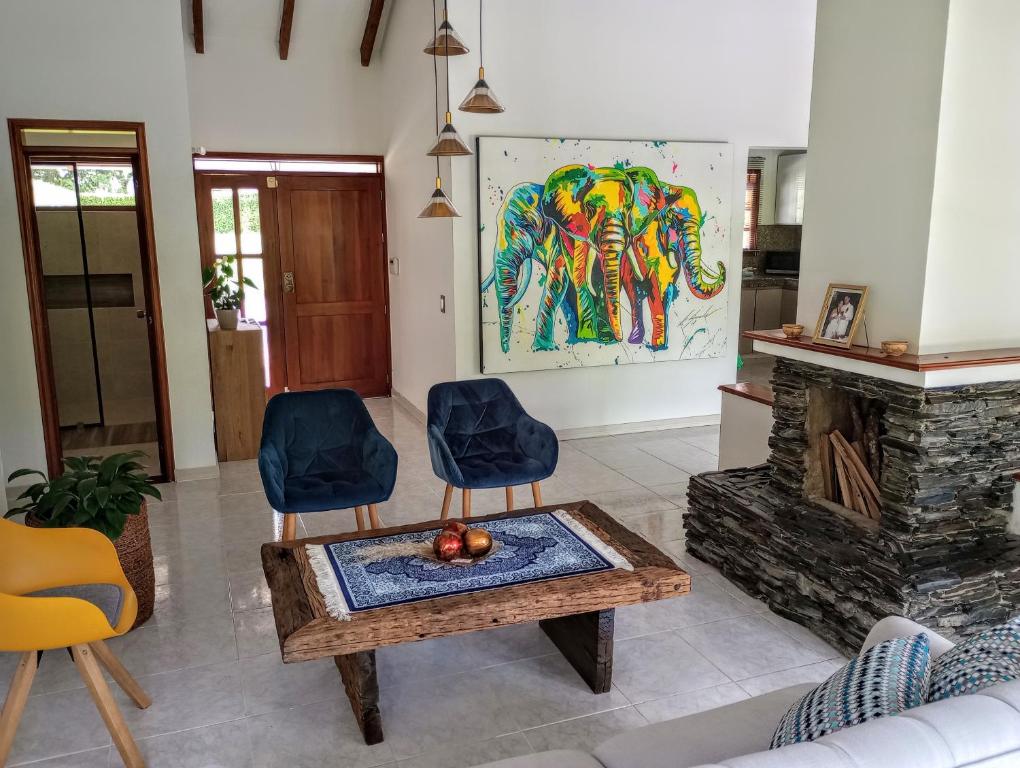 ein Wohnzimmer mit einem Kamin, einem Tisch und Stühlen in der Unterkunft Habitación tranquila en casa campestre in Pereira