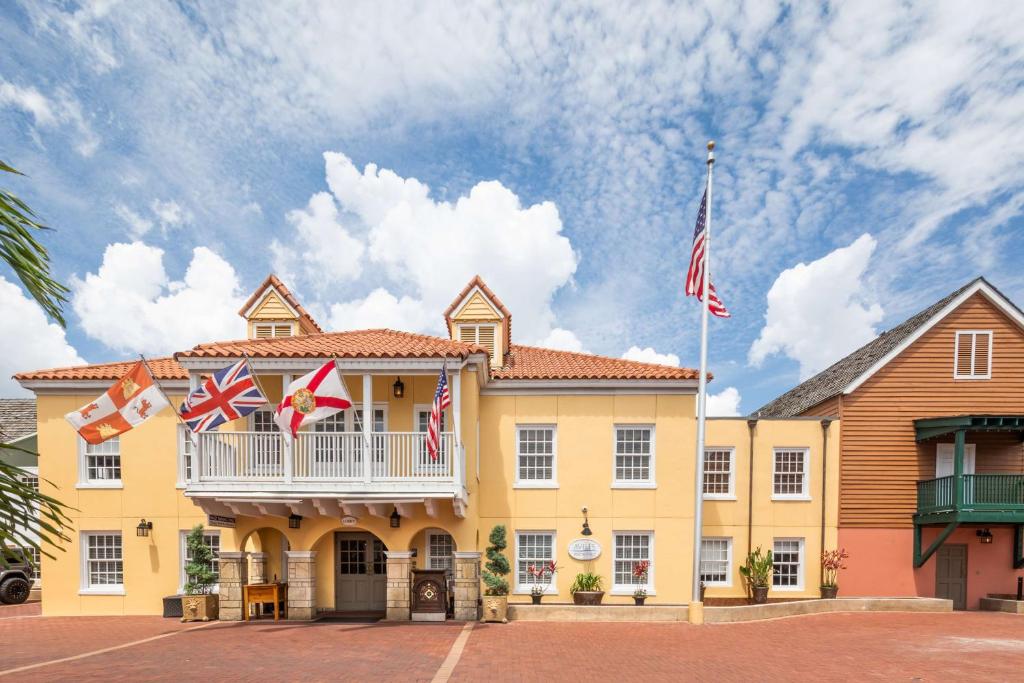żółty budynek z balkonem z flagami w obiekcie Hilton Saint Augustine Historic Bayfront w mieście St. Augustine