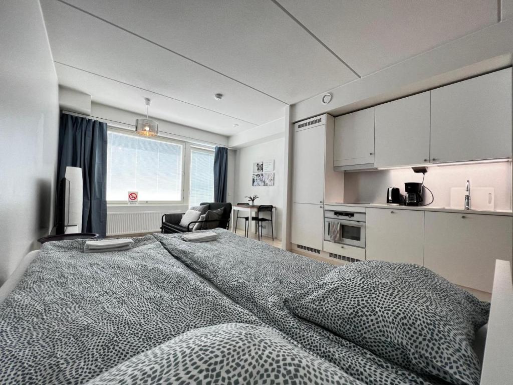 sypialnia z dużym łóżkiem i kuchnią w obiekcie Transit Apartment HEL Airport w mieście Vantaa