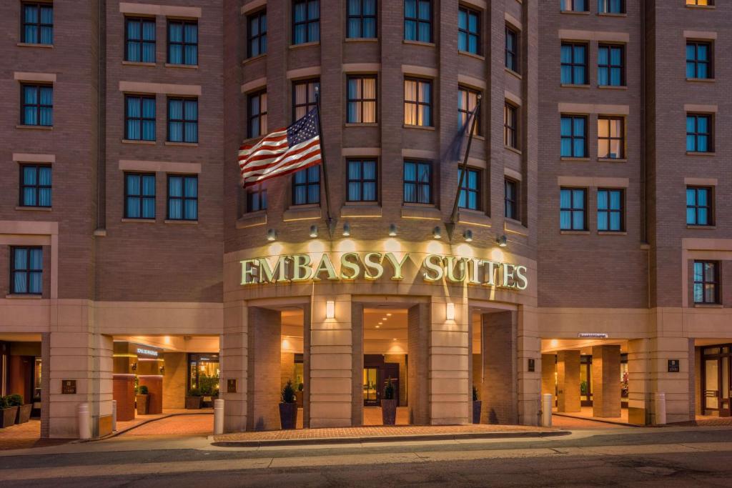 a building with an american flag in front of it at Embassy Suites by Hilton Alexandria Old Town in Alexandria