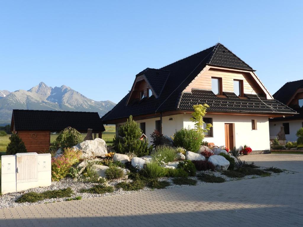 a house with a garden in front of it with mountains at Pinus Cembra in Stará Lesná