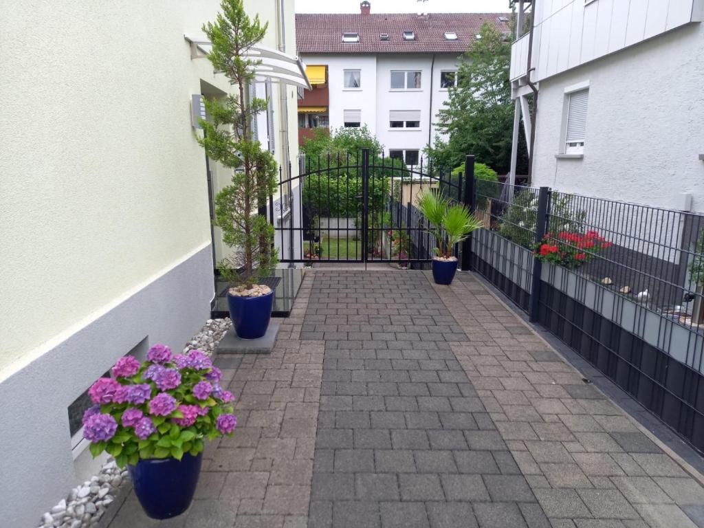 un patio con macetas y flores en una valla en Ferienwohnung Zentral in Lörrach - KONUS Gästekarte inklusive, en Lörrach