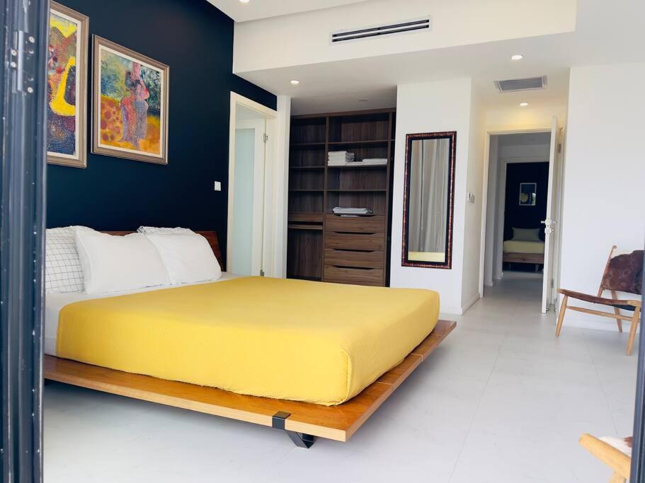 a bedroom with a large yellow bed in a room at Apt 6ix - Modern and Airy @ Paradise Bay in Montego Bay