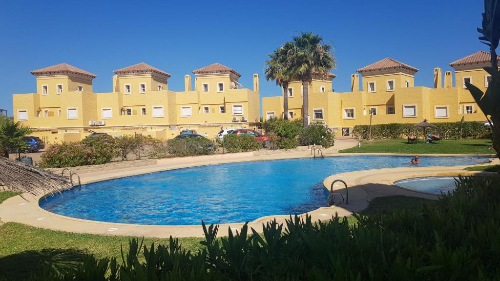 un gran edificio con una gran piscina frente a él en Los olivos apartamento, en Vera