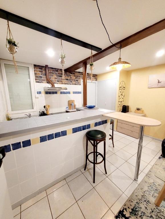 uma cozinha com um balcão e um banco num quarto em Appartements T2 em Tarbes