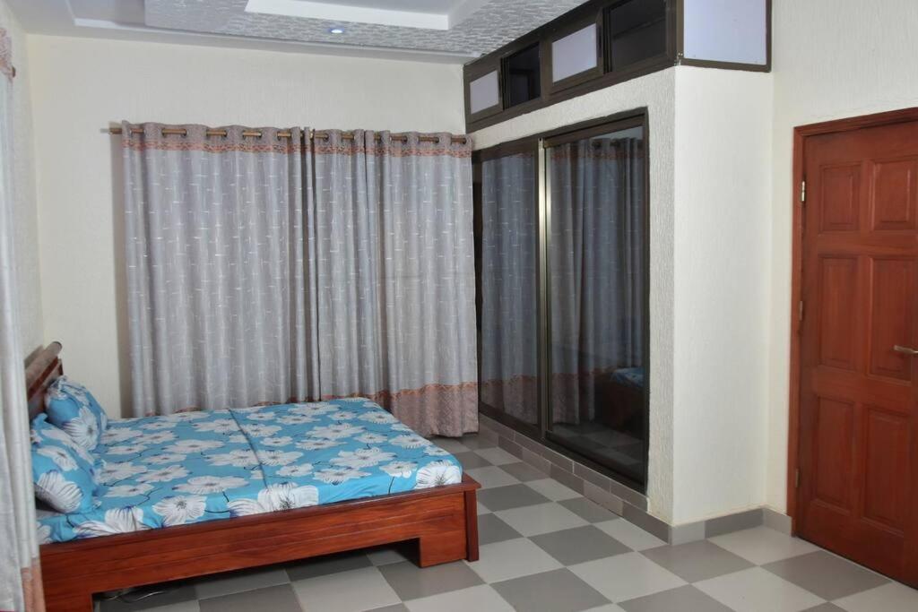 a bedroom with a bed and a window and a television at Residence Patricia in Cotonou