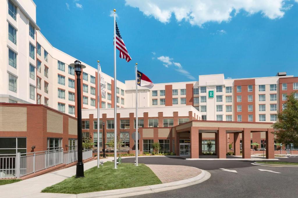 an exterior view of a hotel with an american flag at Embassy Suites Charlotte/Ayrsley in Charlotte