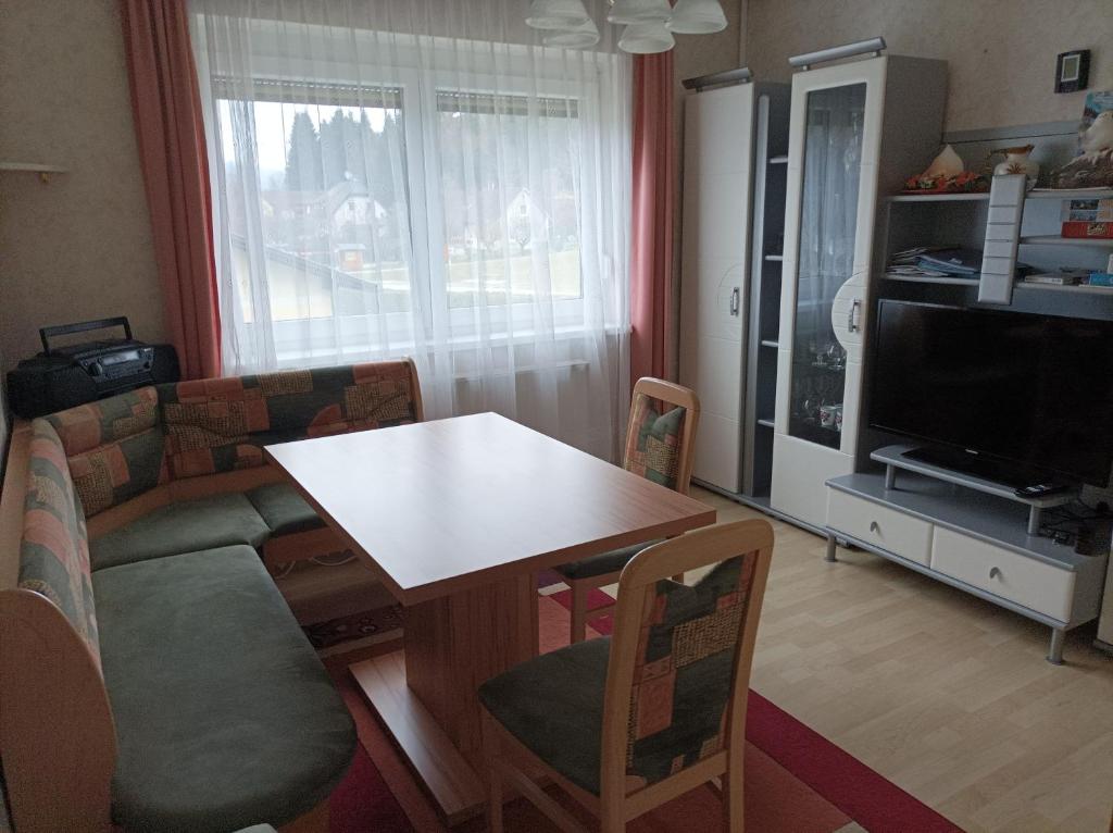 a living room with a table and a television at Appartement Draublick in Unterpudlach