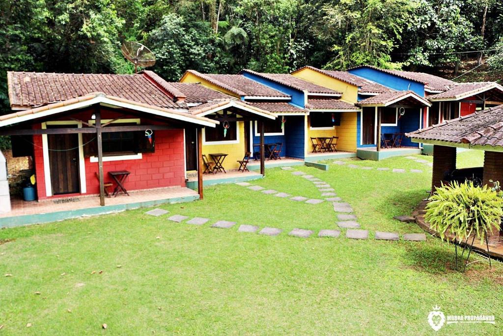 a row of colorful houses in a yard at Eco Chalés Luar das Marés in Ubatuba