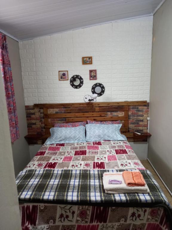 Una cama con edredón en un dormitorio en Habitación Independiente, en Chuy