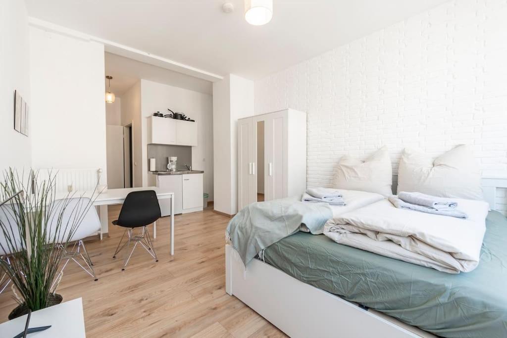 a white bedroom with a bed and a dining room at Stilvolle Wohnung zentral Bremen in Bremen