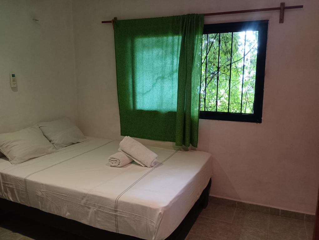 two beds in a room with a window at Alojamiento Ya'ax Nah in Playa del Carmen
