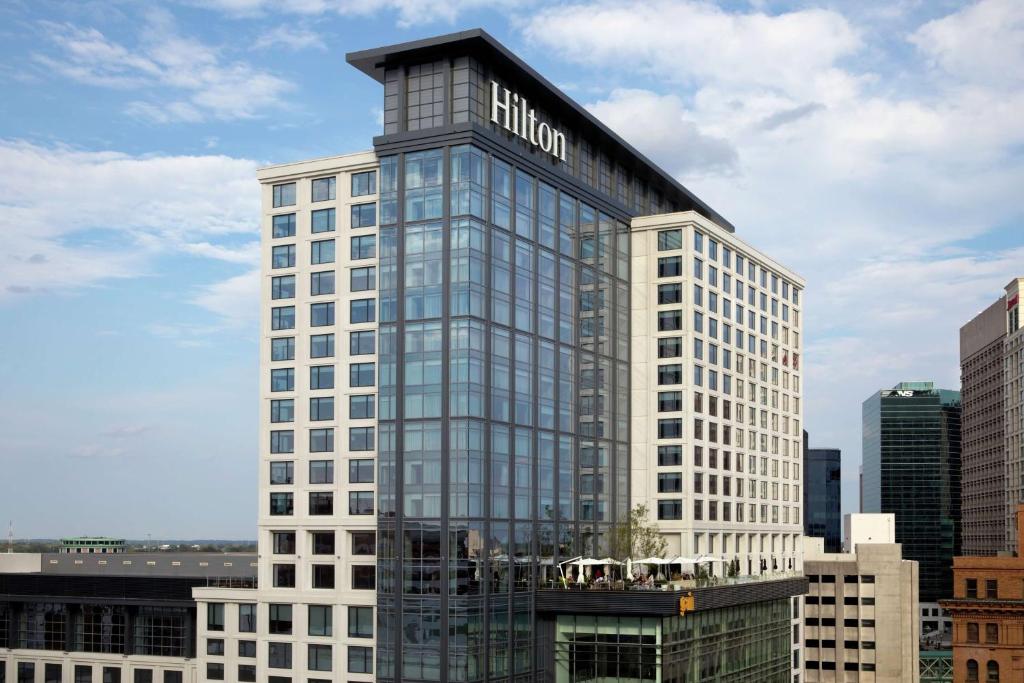 a tall glass building with a hilton sign on it at Hilton Norfolk The Main in Norfolk