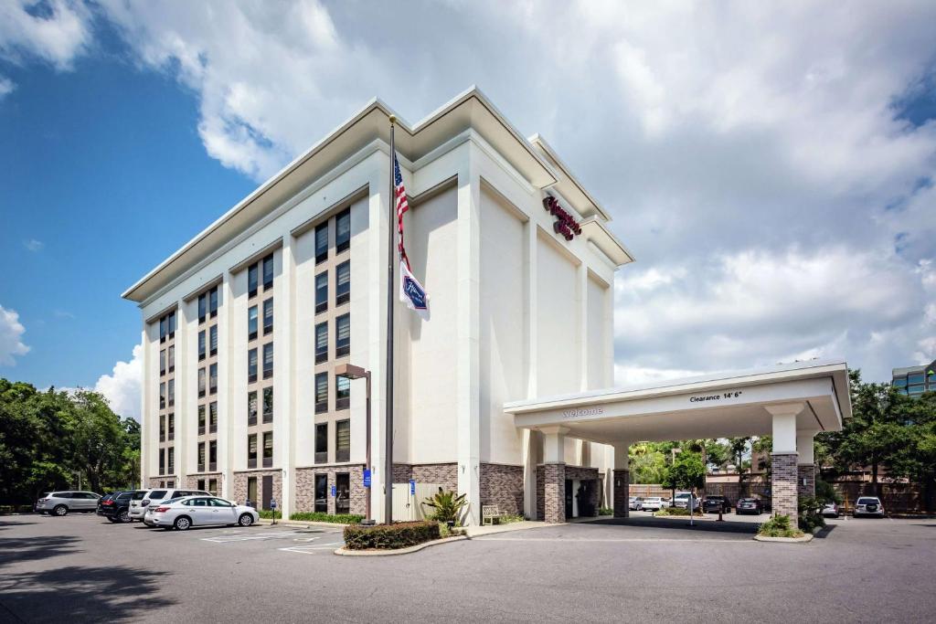 um grande edifício branco com uma bandeira americana em Hampton Inn Tampa International Airport/Westshore em Tampa